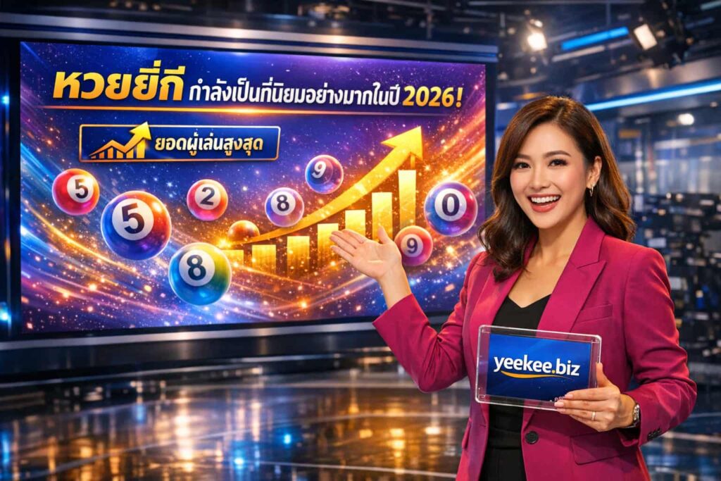 A professional photograph featuring a cheerful Thai female presenter in a high-tech studio pointing toward a large screen. The screen displays vibrant graphics of number balls, rising charts, and bold Thai text that reads "Yee Kee Lottery is becoming very popular in 2026!". The presenter holds a tablet showing the "yeekee.biz" logo.